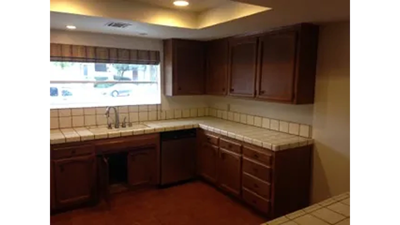 A kitchen with brown cabinets and white counters