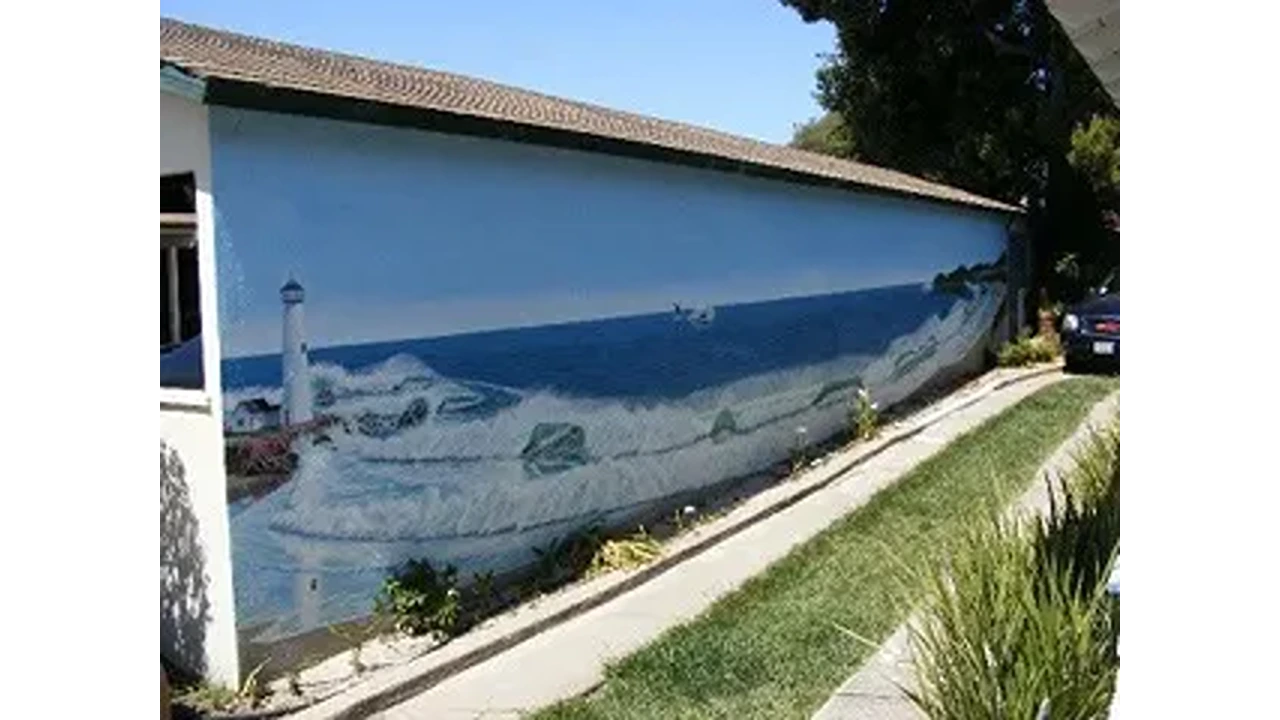 A mural of the ocean and lighthouse on a wall.