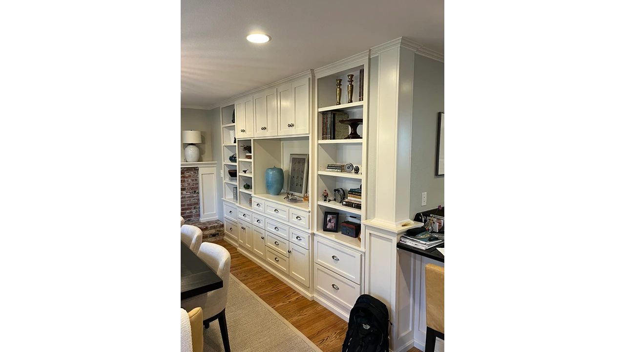 A living room with white cabinets and drawers.